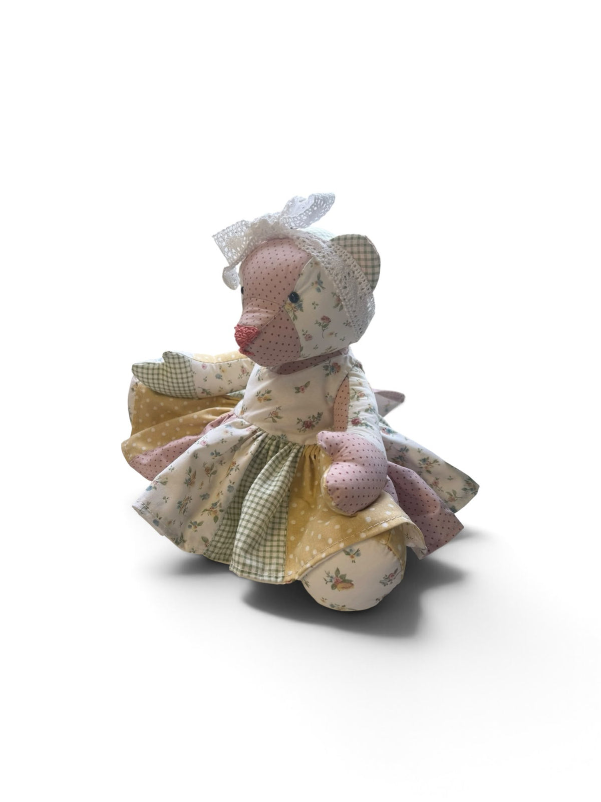 Patchwork bear wearing the finished dress, shown as a sewing example
