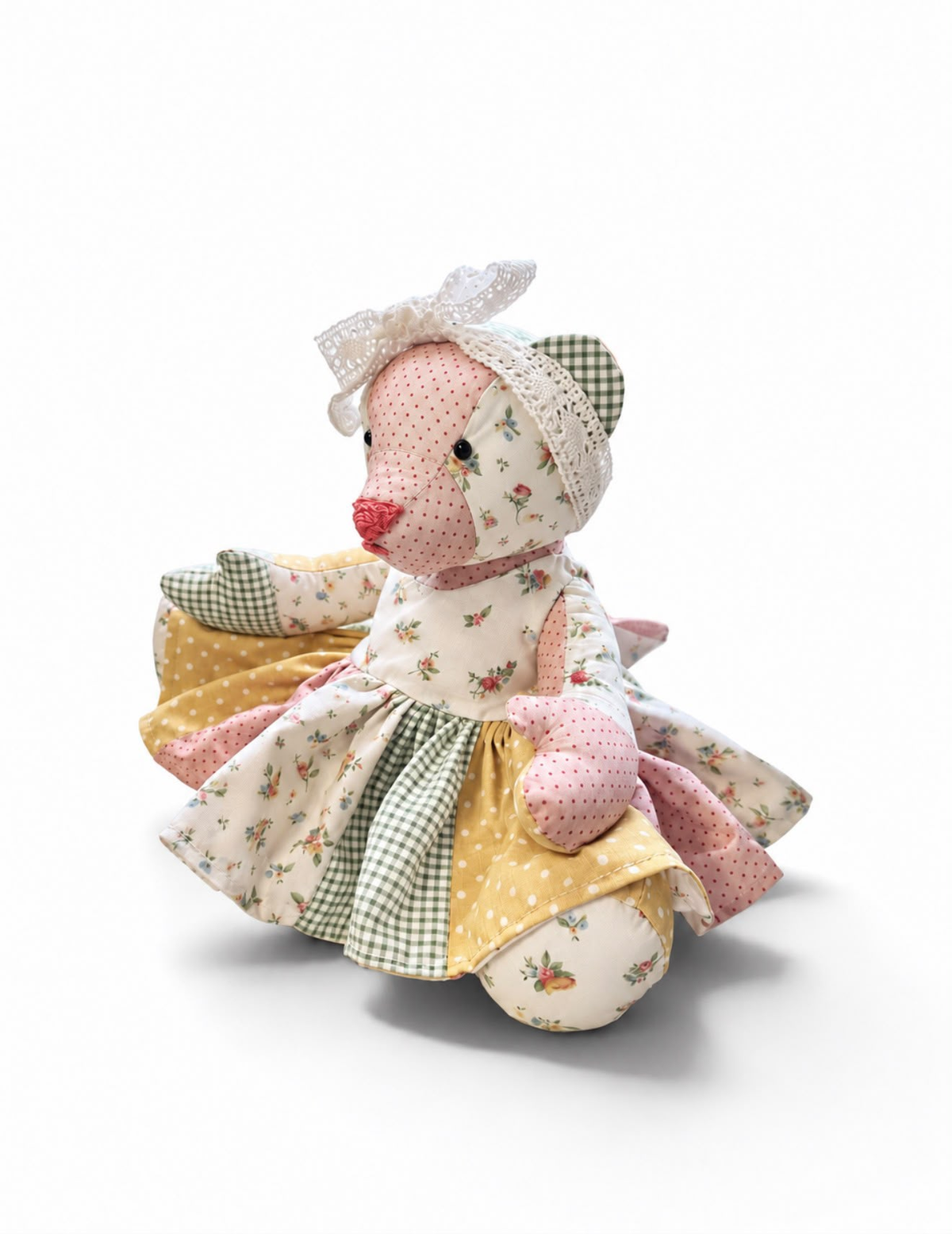 Finished patchwork Queenie Bear in a dress with a lace bow, shown as an example of the sewing pattern.