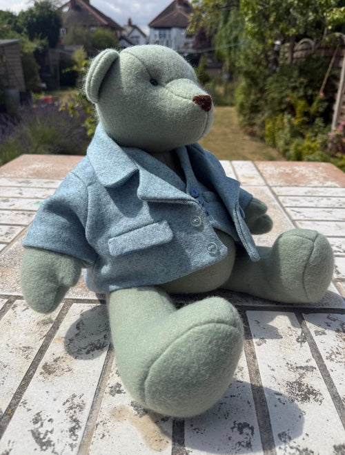 Bear wearing the finished blue jacket, shown as a sewing example